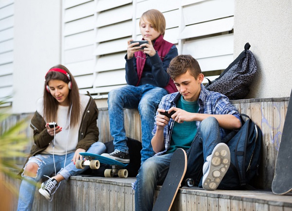 Teenagers looking at their smartphones
